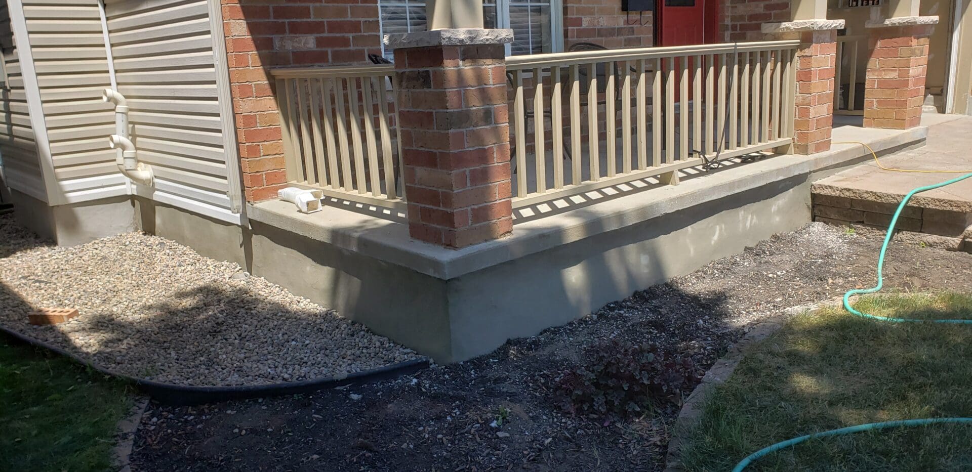 Freshly resurfaced concrete on the foundation of a red bricked home