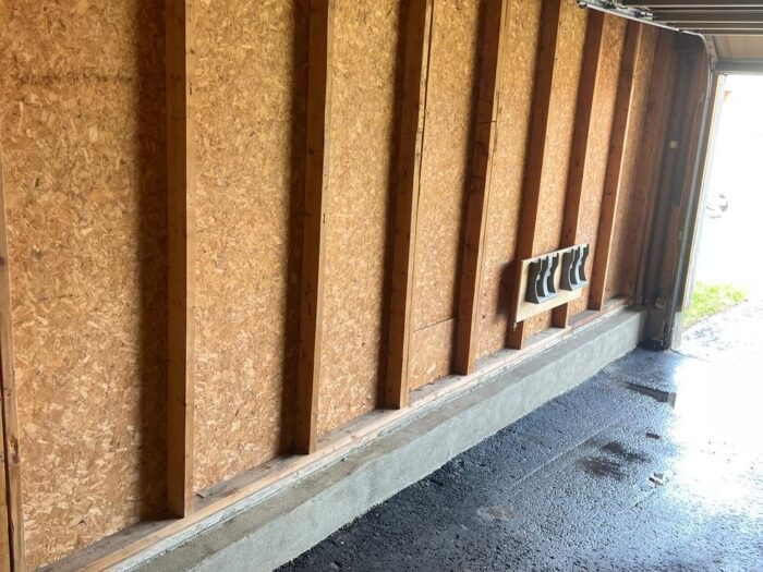 New concrete footing poured along a garage wall