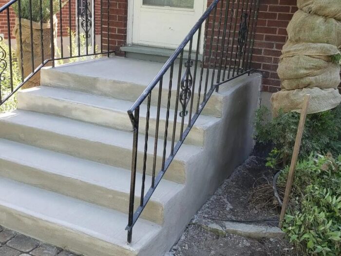 New concrete steps with a handrail set in place