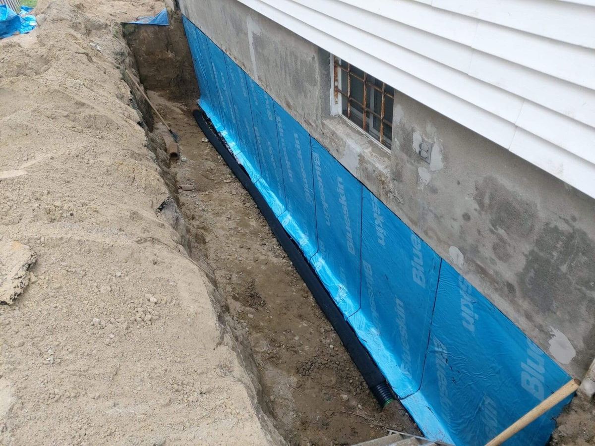 Waterproofing membrane applied to an exposed foundation wall
