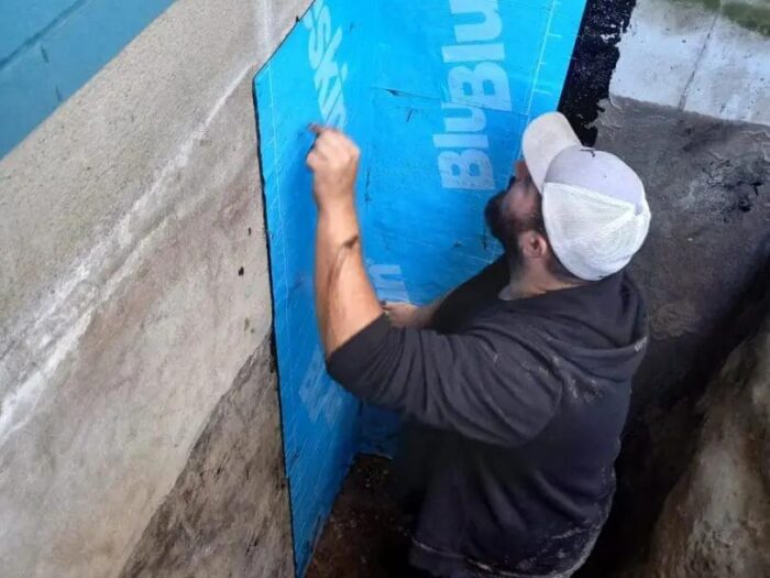Insulation board fitted against a waterproofed foundation
