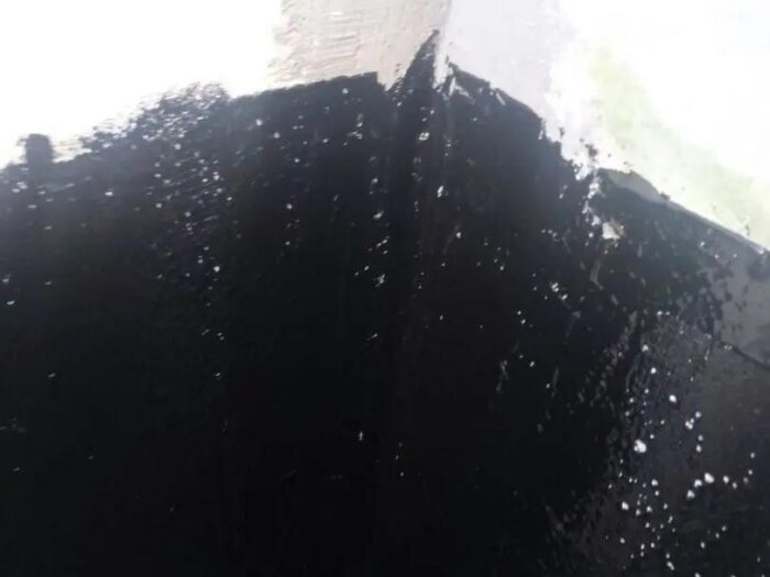 Tar coating applied over a repaired foundation wall