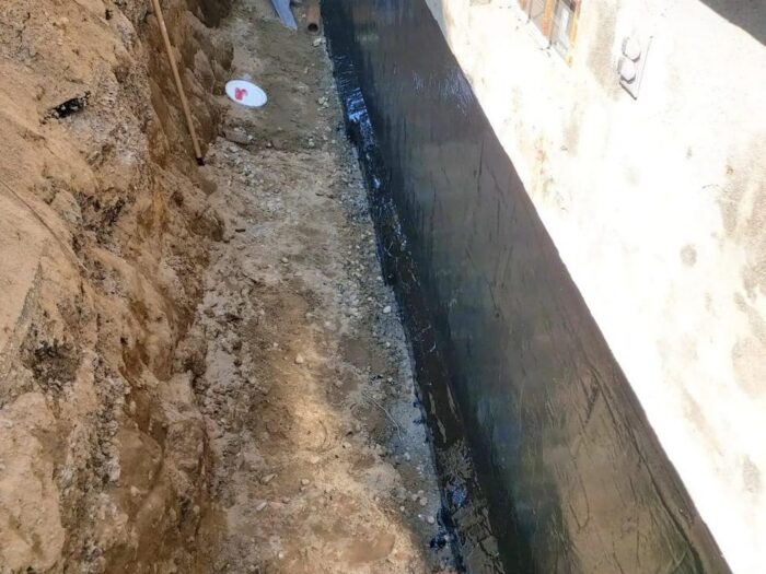 Drainage stone backfilled against a sealed wall