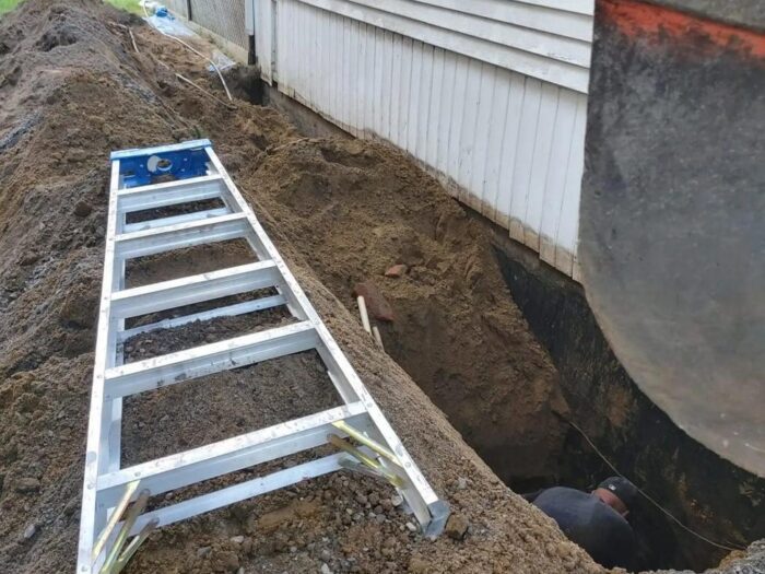 Trench dug the length of a foundation for waterproofing