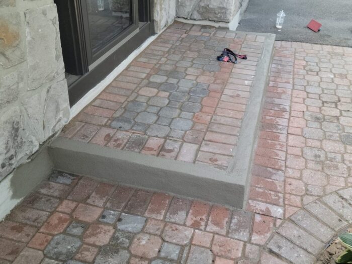 Interlock entrance step re-set beside a stone wall