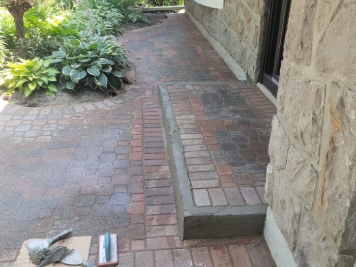 Re-levelled brick and cobble walkway to a front door