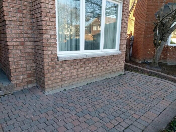 Repointed brick wall beside a basement window