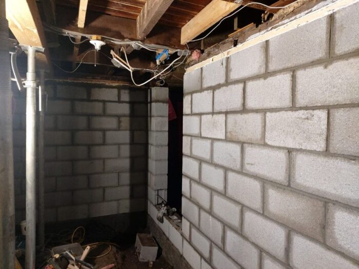 Block wall rebuilt under an existing structure