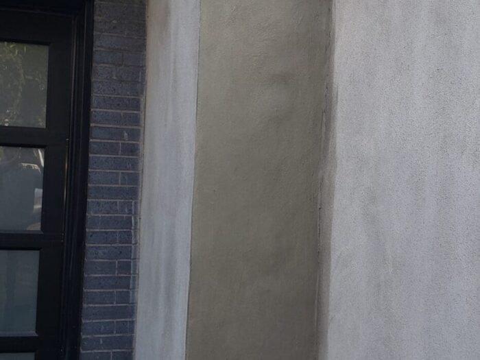 Smooth parged finish beside a front entrance