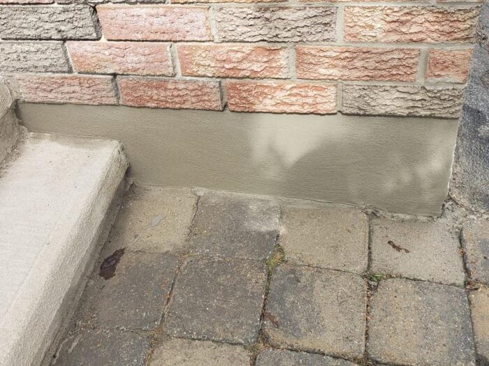 Close-up of a finished parging coat below the brick line