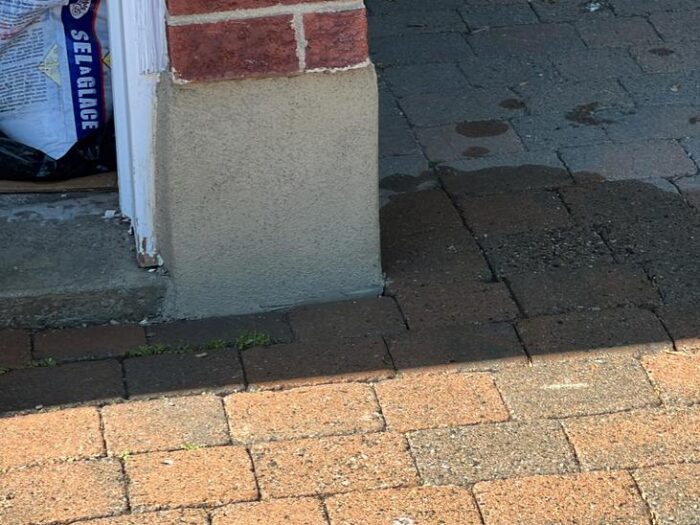 Parged brick pillar base at a front porch
