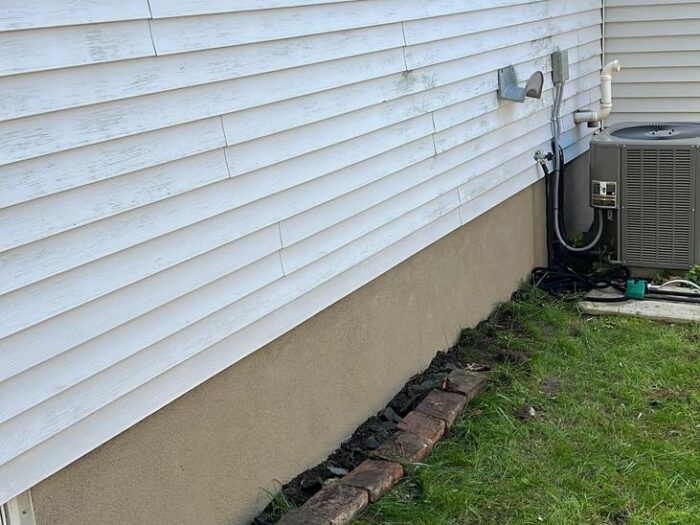 Parged foundation below vinyl siding