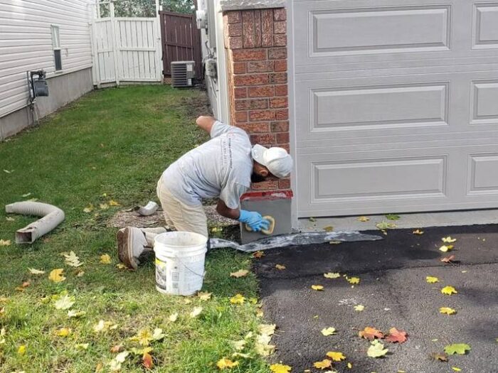Applying parging along the base of a garage wall