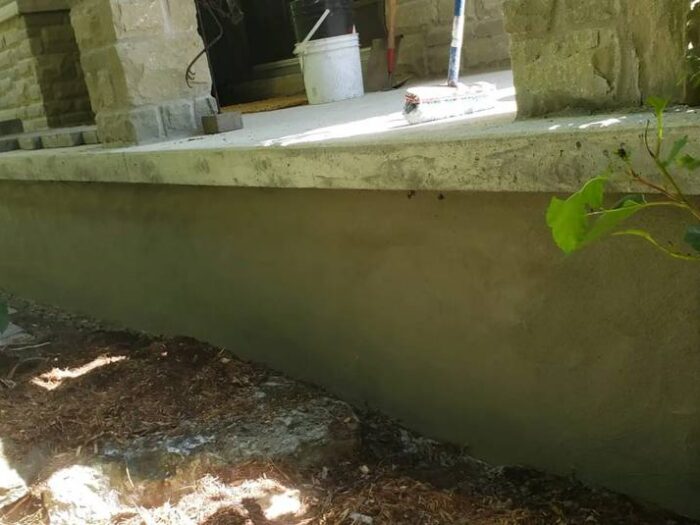Parged foundation beside a garden bed