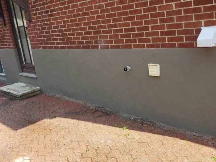 Parged foundation wall above an interlock walkway
