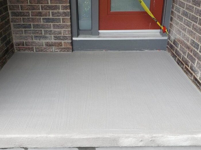 Resurfaced concrete walkway leading to a front door