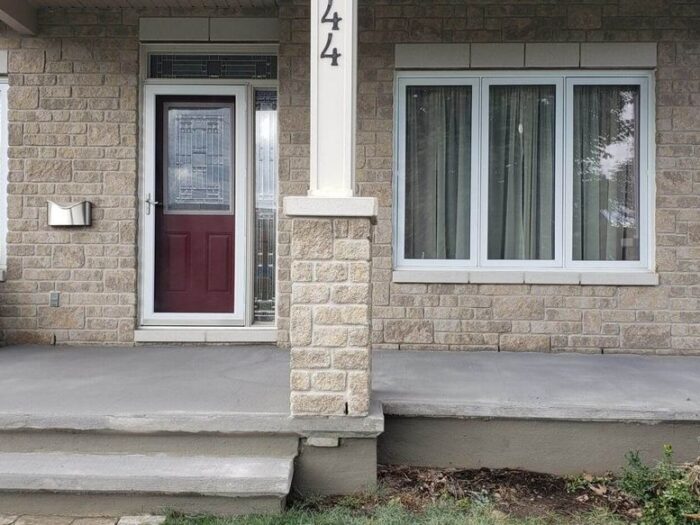 Resurfaced porch and steps at a stone-fronted house