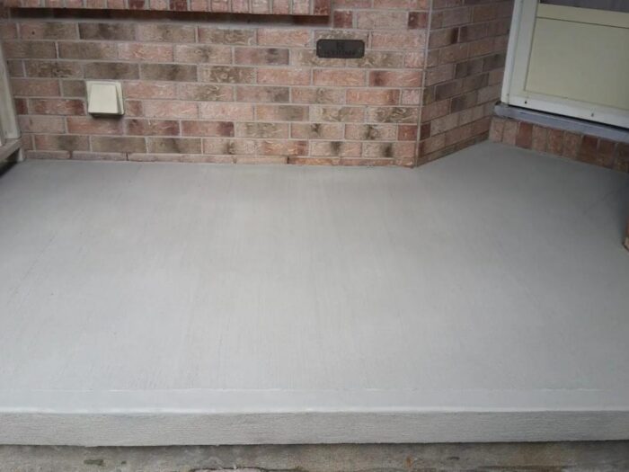 Resurfaced concrete landing at a brick entrance