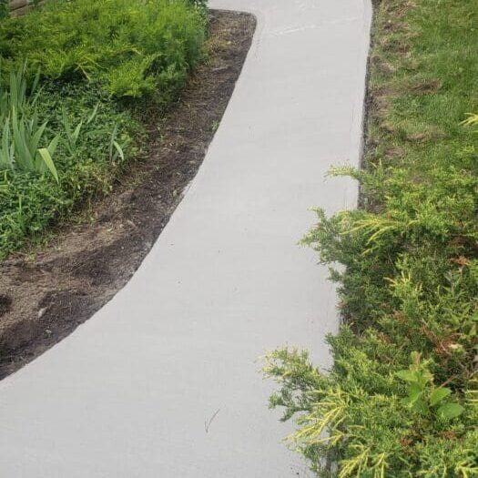 Resurfaced curved walkway through a front garden