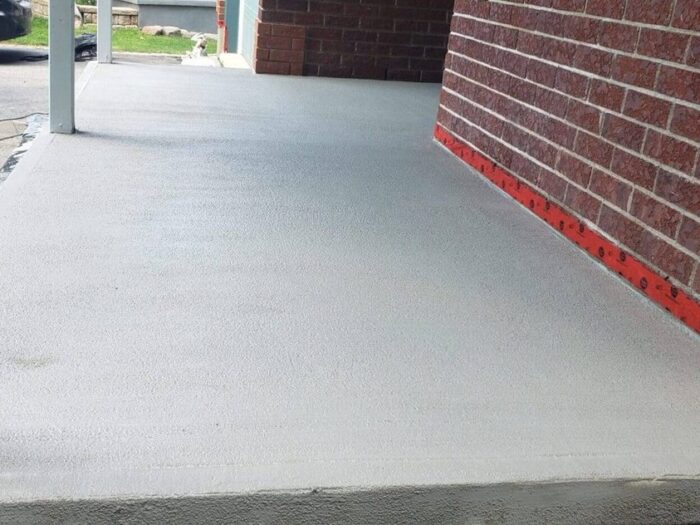 Resurfaced carport slab beside a brick wall