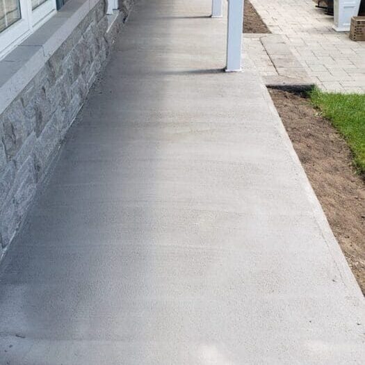 Resurfaced side walkway beside a covered porch