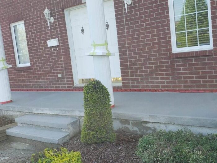 Resurfaced entrance steps beside a red brick wall